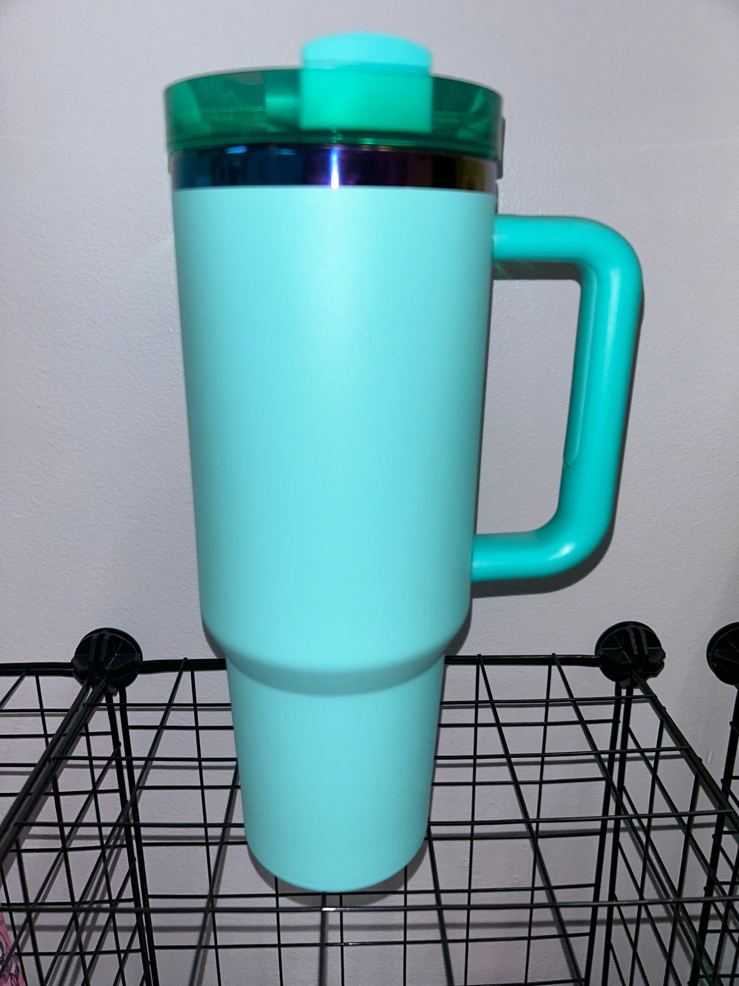 Close-up of a 40oz Rainbow Stainless Steel Tumbler with a handle, available in black pearl, white, light pink, hot pink, and teal, showcasing the sleek, insulated design perfect for hot and cold beverages.